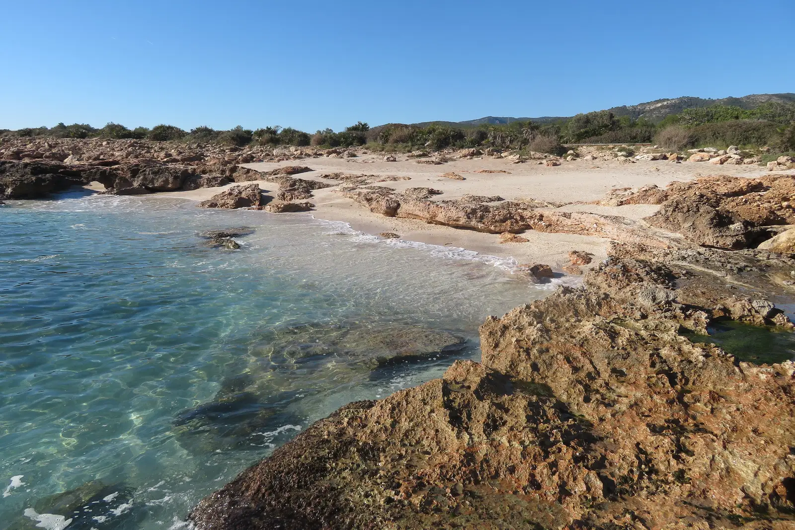 Bucht mit Sand, Felsen und klarem Wasser an der Küste der Serra d'Irta